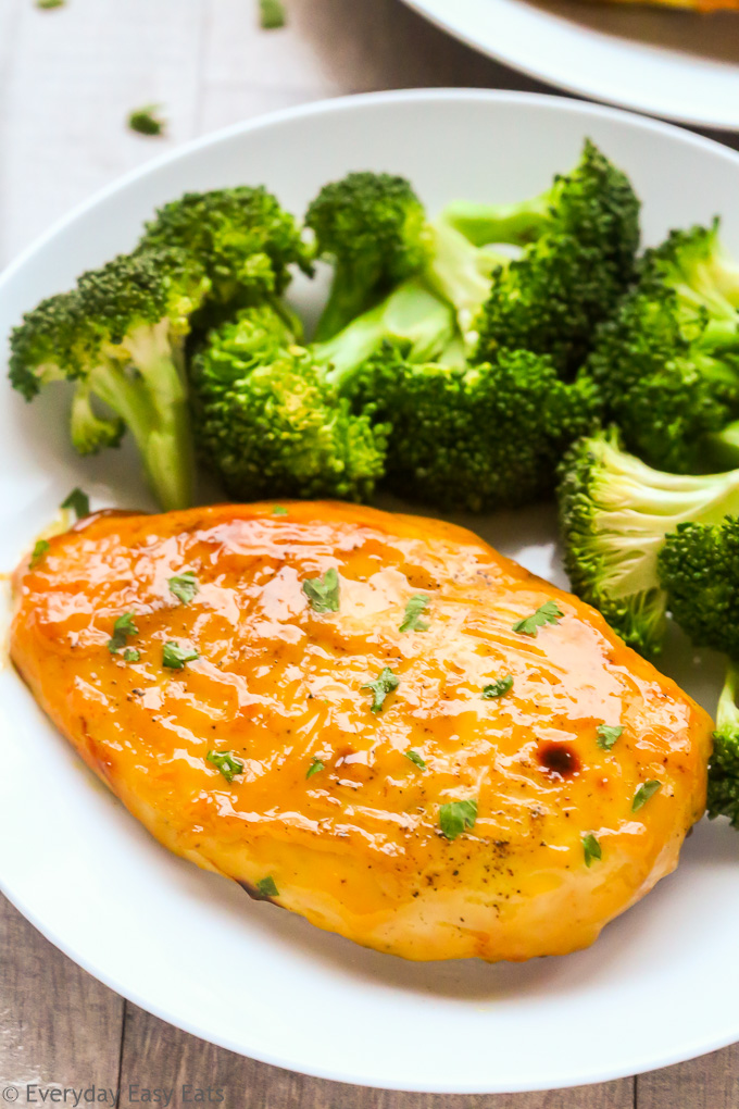 Healthy Meat Recipe: Close-up overhead view of Healthy Baked Honey Mustard Chicken Breasts in a white plate with steamed broccoli.
