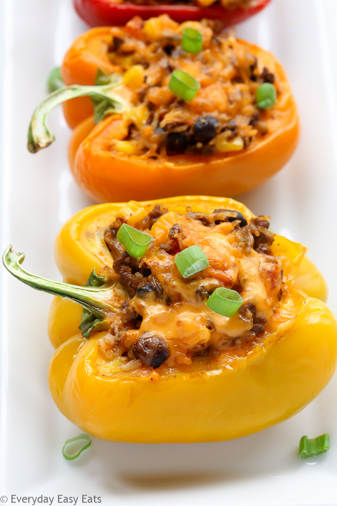 Budget-Friendly Meals: Close-up side view of Mexican Stuffed Peppers in a white plate on a white background.